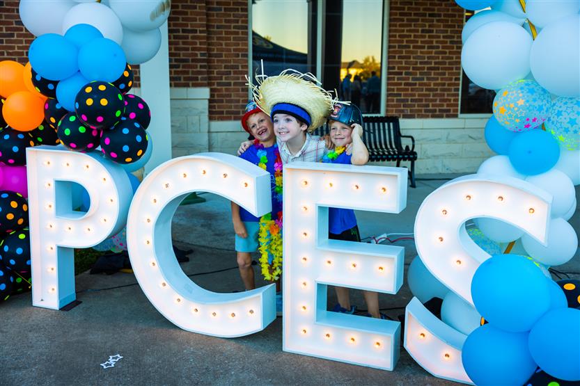 Students take a photo with a PCES sign